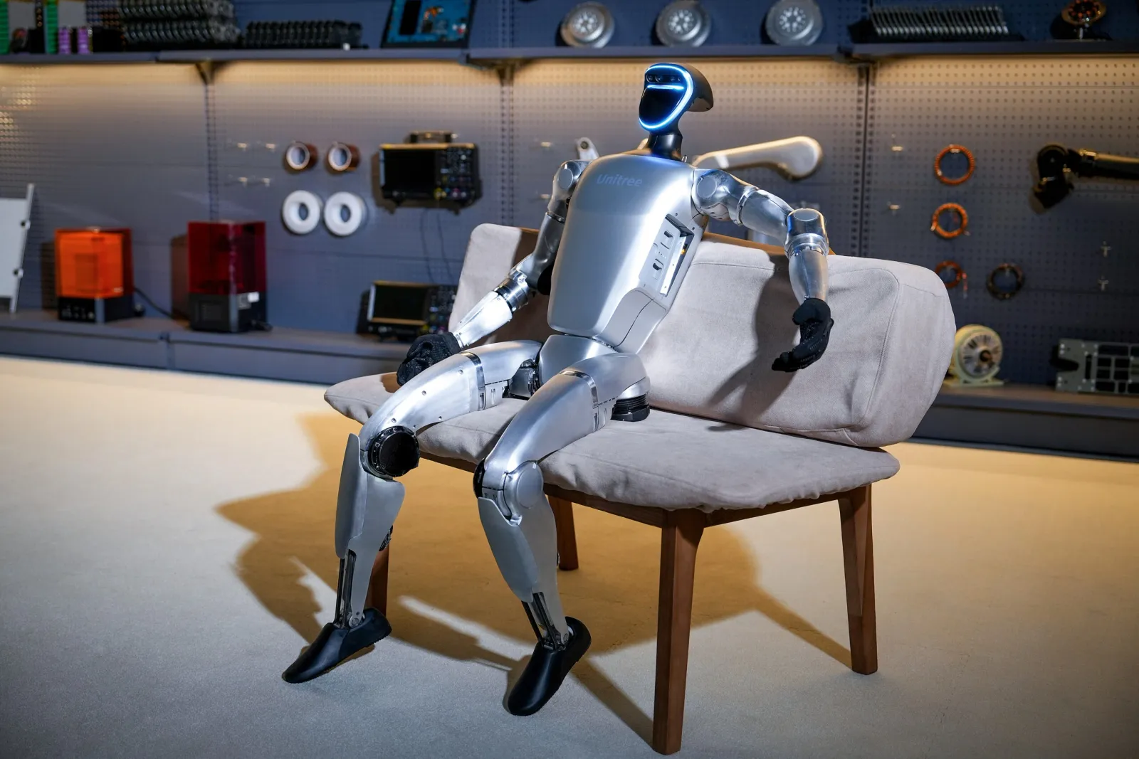 A RentRobots humanoid robot seated in a workshop